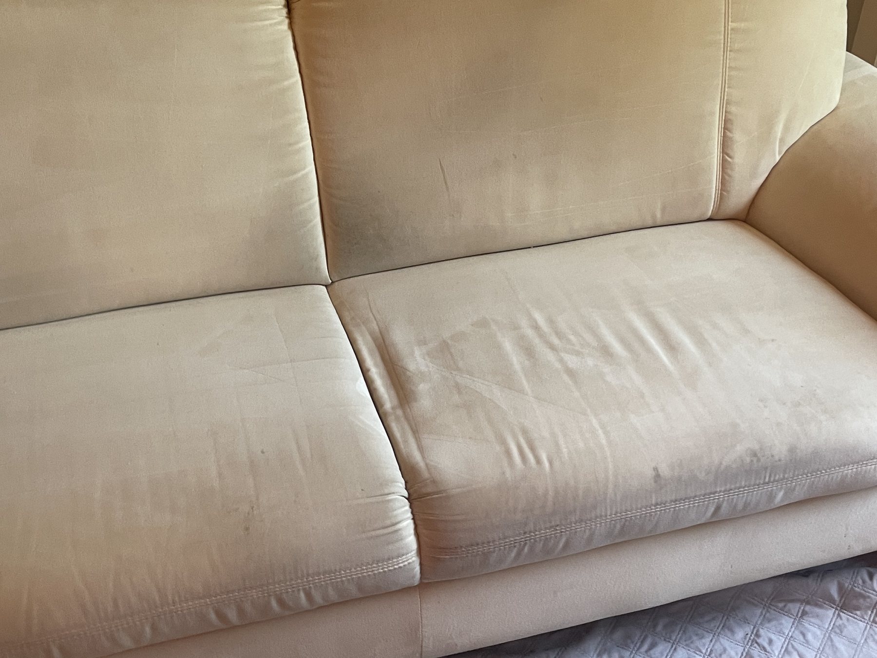 Verschmutztes helles Sofa vor der Reinigung